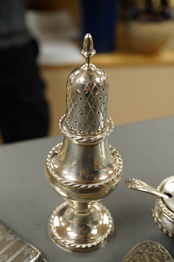 A modern silver pepperette, Birmingham, 1988, 14cm, a silver mustard pot and associated silver spoon, a silver mounted notecase and a filigree white metal card case.